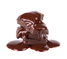 Chocolate pieces stack and chocolate syrup isolated on white background. Close up.