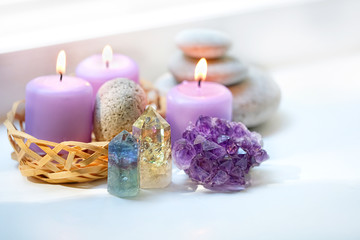 Fototapeta na wymiar fluorite, quartz, amethyst geode crystal, candles, spa stones on white background. Spa therapy composition. Ritual for relaxation, meditation. close up. soft selective focus
