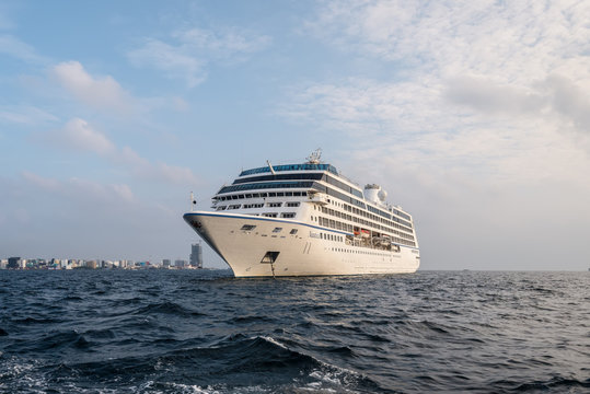 Male, Maldives - November 17, 2017: Oceania Cruises Nautica Cruise Ship is anchored in the outer harbor of Male island as seen from the boat in Maldives, Indian Ocean.