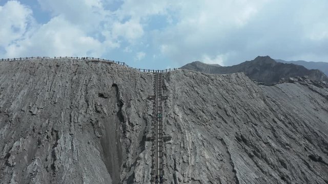 Aerial drone view climbing slowly up to reveal an active volcano crater (Mount Bromo, Java, Indonesia)