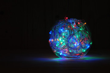 Christmas and New Year's garland of multi-colored light bulbs in a glass aquarium