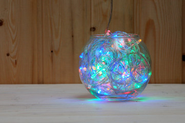 Christmas and New Year's garland of multi-colored light bulbs in a glass aquarium