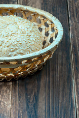 Fototapeta na wymiar top view of a wheat bun with sesame topping in a straw basket on the kitchen table