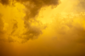 Orange color fluffy clouds on sunset time under dark blue sky