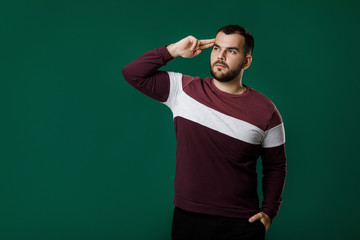 portrait of bearded man thinking and asking questions on green background. copy space