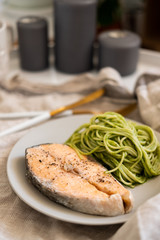 green spaghetti and grilled salmon steak. Top view