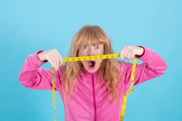 closeup of astonished woman looking at measuring tape, diet and slimming