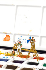 Miniature scale model painters decorators on a watercolour palette set.  Painting decorating concept
