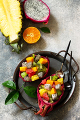 Healthy diet detox fruit salad in summer in a bowl of dragon fruit on a stone blue countertop.