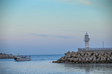 Fototapeta premium lighthouse. A lighthouse on the coast. A lighthouse on a breakwater. Lighthouse and Tetrapod.