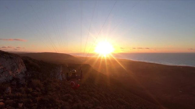 Beauty of free paragliding flying at sunset in ocean coast mountains in Morocco. Adrenaline adventure Slow motion