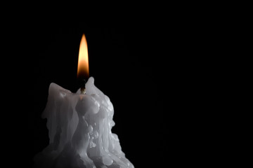 molten, burning candle on a metal candlestick