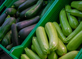 The squash and zucchini in the boxes in the store