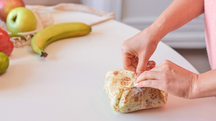 Woman hands wrapping a healthy sandwich in beeswax food wrap
