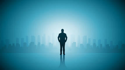 Fototapeta na wymiar Silhouette business man standing on top of building looking at cityscape view on blue color background