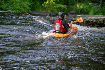 man kayaking in river