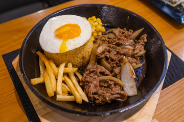 Sizzling beef fillet rice served with french fries and egg