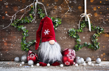 Christmas composition with gnome and festive decorations on wooden background. Christmas or New...