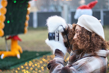 Cute curly hair girl taking photos with the camera