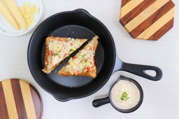 Chili Cheese toast, Open cheese sandwich or mini bread pizzas served with mayonnaise deep and garnished with chopped Basil leaves.