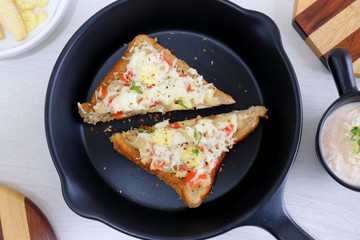 Chili Cheese toast, Open cheese sandwich or mini bread pizzas served with mayonnaise deep and garnished with chopped Basil leaves.