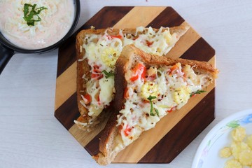 Chili Cheese toast, Open cheese sandwich or mini bread pizzas served with mayonnaise deep and garnished with chopped Basil leaves.