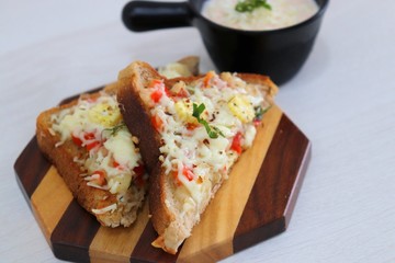 Chili Cheese toast, Open cheese sandwich or mini bread pizzas served with mayonnaise deep and garnished with chopped Basil leaves.