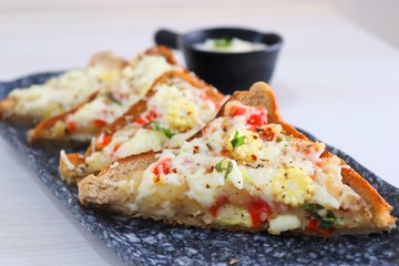 Chili Cheese toast, Open cheese sandwich or mini bread pizzas served with mayonnaise deep and garnished with chopped Basil leaves.