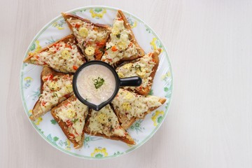 Chili Cheese toast, Open cheese sandwich or mini bread pizzas served with mayonnaise deep and garnished with chopped Basil leaves.