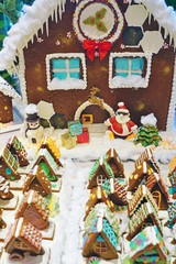 A Christmas gingerbread cookie house decorated with colorful candy for the holidays