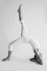 monochrome portrait of caucasian blonde beautiful cheerful woman doing yoga asanas. Healthy lifestyle and sport concept