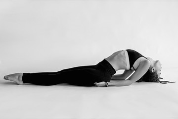 monochrome portrait of caucasian brunette beautiful cheerful woman doing yoga asanas. Healthy...