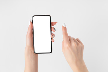 Female hand holding and touching on mobile smartphone with white screen. Isolated on white. Photo template for any images on mobile phone display Layout with easily removable phone monitor background