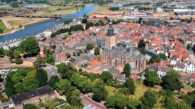 Aerial day time sunny weather shot of historic city center of city of Zutphen, Netherlands. Shot of famous church St. Walburgis, flying sideways, including view on river Ijssel