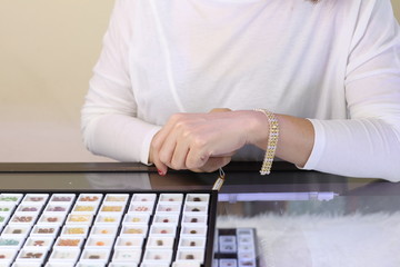 Obraz premium Gemstone bracelet on seller hand while customer try on for buying
