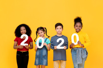 Cute mixed race kids smiling and holding 2020 numbers