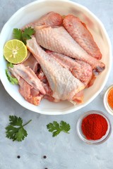 Clean and Raw Free range or country chicken carved in parts in a bowl with Indian spices and cooking ingredients. Along with copy space