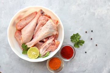 Clean and Raw Free range or country chicken carved in parts in a bowl with Indian spices and cooking ingredients. Along with copy space