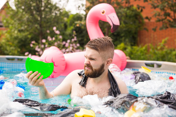 Ecology, plastic trash, environmental emergency and water pollution - shocked man swim in a dirty...