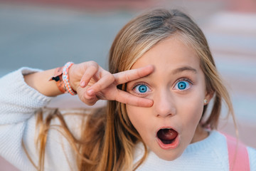 Portrait of little happy student girl with blue eyes