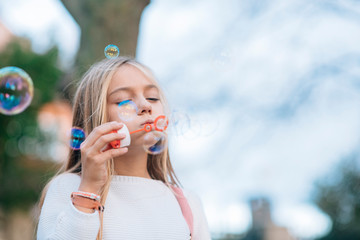 Obraz premium Little girl blowing soap bubbles