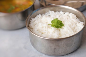 Stainless steel Lunch Box or Tiffin with Indian food menu Chapati or Roti, Garlic Dal Tadka, White Rice and Potato or Jeera aloo. with spoons, tissue paper and glass of water. Copy space