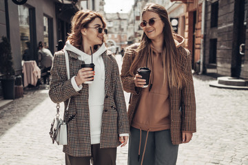 Fototapeta premium Portrait of Two Fashion Girls, Best Friends Outdoors, Coffee Break Lunch