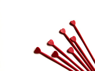 Red plastic sticks for canapes with a heart on a white isolated background. Copy space.