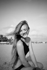 A young blonde laughs in beach, in black and white