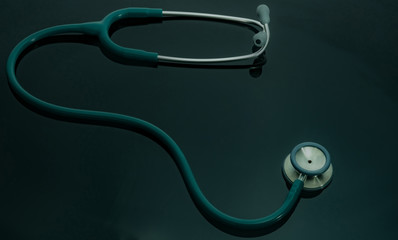 Green stethoscope on doctor table or nurse desk. Health checkup or health insurance concept....