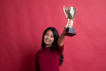 Successful young asian woman holding a trophy.