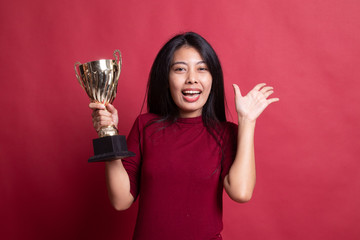Successful young asian woman holding a trophy.