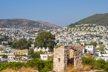 Panoramic view from the walls of  Bodrum castle (also known as St Peter Castle) in Bodrum. Famous white cubic buildings, blue Aegean sea and green nature on the background, Mugla, Turkey.