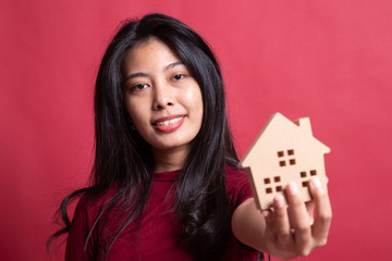 Happy young asian woman with house model.